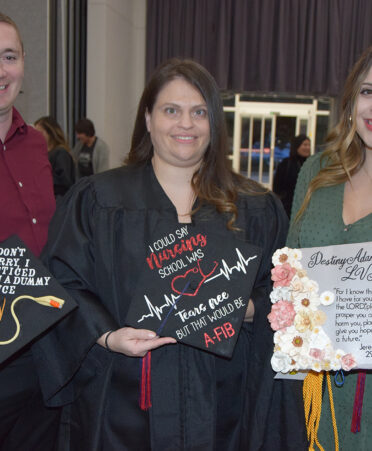 Three women holding graduation caps