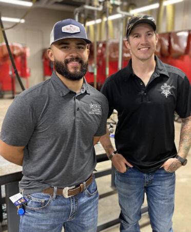 two men standing in welding shop