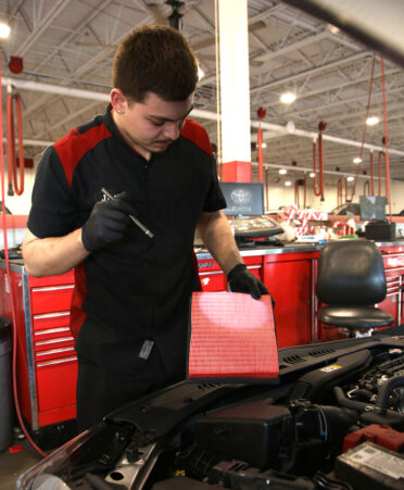 TSTC Automotive Technology alumnus Jesus Resendez checks the air filter on a 2024 Toyota Camry as part of his job at Toyota of Pharr.