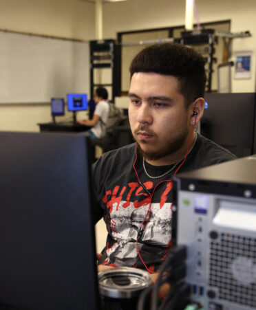 Daniel Riano, a third-semester Cybersecurity student at TSTC, watches a video introduction about networking during a recent lab session.