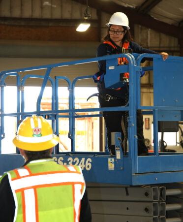 Lea Escalera (right), a TSTC Building Construction Technology student, learns how to operate a scissor lift by listening to directions from Rene Rodriguez, a Building Construction Technology instructor, during a recent lab session.