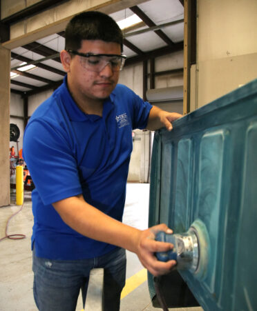 Dominick Zavala, a TSTC Auto Collision and Management Technology student, buffs a panel as part of a refinishing project on a 1988 Chevrolet pickup during a recent lab session.