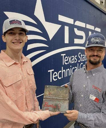 Two men holding a welding playe
