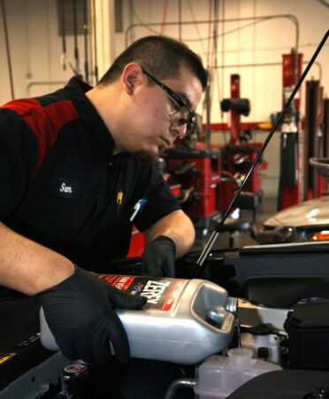 TSTC Automotive Technology alumnus Samuel Gonzales adds antifreeze to a 2024 Toyota Camry as part of his job at Toyota of Pharr.