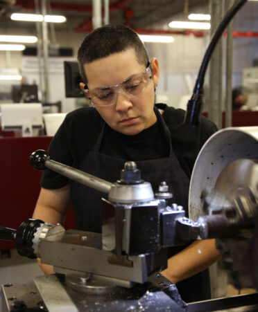 Selena Gomez, a TSTC Precision Machining Technology student, uses a high-speed lathe to cut steel during a recent lab session.