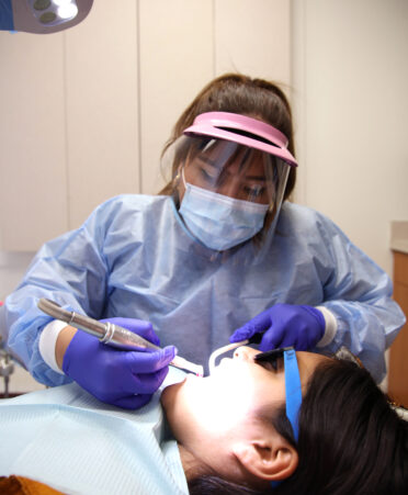 TSTC Dental Hygiene alumna Joanna Cerda (top) gives a dental cleaning to her daughter Sadie at Su Clinica.