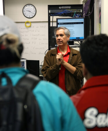 During TSTC’s TechXperience Day on Thursday, Feb. 29, Cybersecurity instructor Alejandro Alcoser (center) explains to visiting high school students how his students learn how to prevent cybercrimes.
