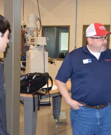 man in red hat looking at equipment