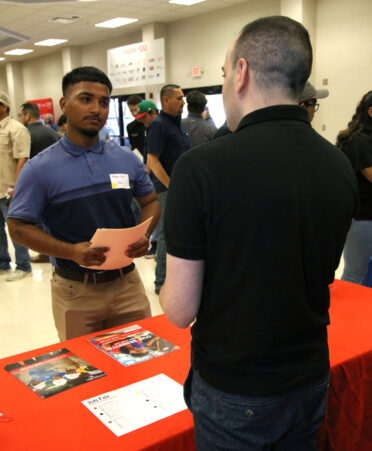 Arturo Solis (left), a TSTC Electrical Lineworker and Management Technology student, visits with Julio Malumay, a senior talent acquisition specialist for American Electric Power, at the recent Industry Job Fair held at TSTC’s Harlingen location.