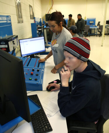 Kevin Hill (right), a TSTC Mechatronics Technology student, practices using a programmable logic controller while fellow student Mia Segueda tests for inconsistencies in preparation for the 2024 SkillsUSA Texas Postsecondary Leadership and Skills Conference.