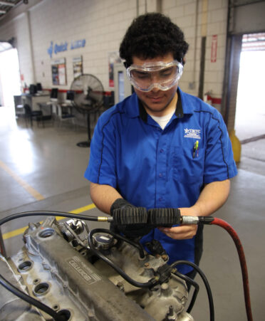 Julius Gutierrez, an Automotive Technology student at TSTC, checks a gauge for a leak in the combustion chamber of a 2.0-liter engine during a recent lab session.