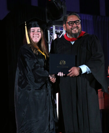 Eladio Jaimez (right), provost at TSTC's Harlingen location, hands Holly Hargrove her diploma for her Associate of Applied Science degree in Business Management Technology during TSTC’s Spring 2024 Commencement.