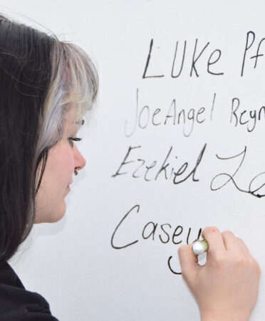 woman signing her name on turbine blade