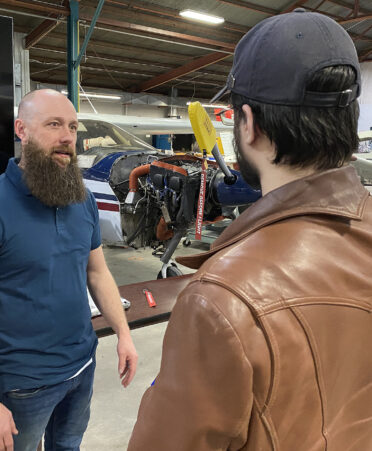 two men talking in an airport hangar