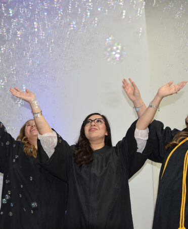 three women in graduation gowns