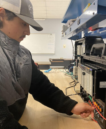 man in hat working on an electronic device