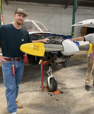 two men standing next to airplane