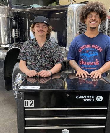 two men standing behind tool box