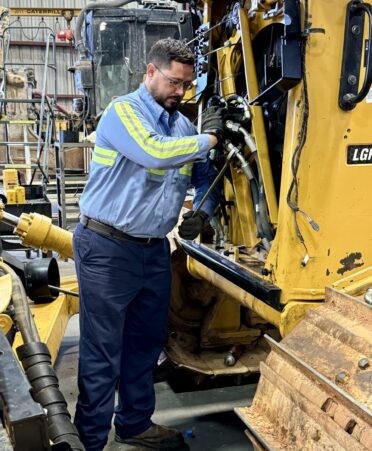 TSTC Diesel Equipment Technology alumnus Autry Adams is shown tightening hoses on a Caterpillar D6 bulldozer’s hydraulic fan system at HOLT CAT’s Longview location. (Photo courtesy of TSTC.)