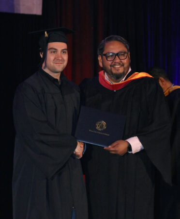Eladio Jaimez (right), provost at TSTC's Harlingen campus, presents Caleb Gaul his Associate of Applied Science degree in HVAC Technology during TSTC’s Summer 2024 Commencement.