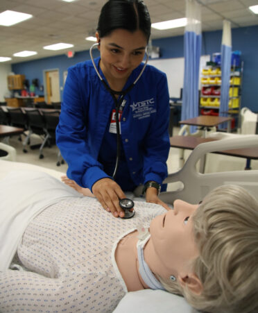 Arlene Vargas, a TSTC Vocational Nursing student, uses a stethoscope to listen to the lung sounds on a medical manikin during a recent lab session.