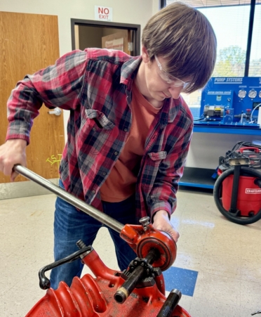 Nicholas Fuller, an Industrial Systems student at TSTC’s Marshall campus, threads pipe in one of the program’s hands-on labs. (Photo courtesy of TSTC.)