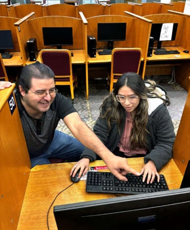 Gabriel Garcia (left), a TSTC Cybersecurity student, helps Mayra Frias-Cervantes, a TSTC Education and Training student, look for her spring 2025 class schedule on a computer in the Learning Resource Center at TSTC’s Harlingen campus.