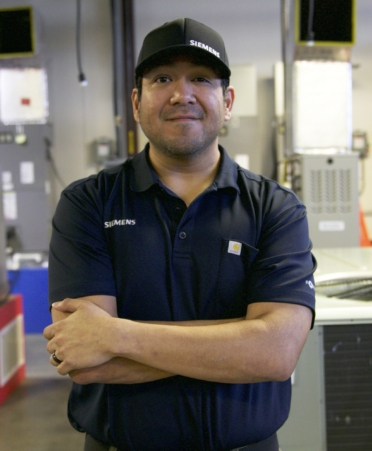 TSTC HVAC Technology alumnus Robert Ortiz stands in the HVAC Technology lab at the college’s Williamson County campus during a recent visit.