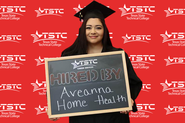 TSTC graduate posing in cap & gown holding a chalkboard showcasing their new employer.