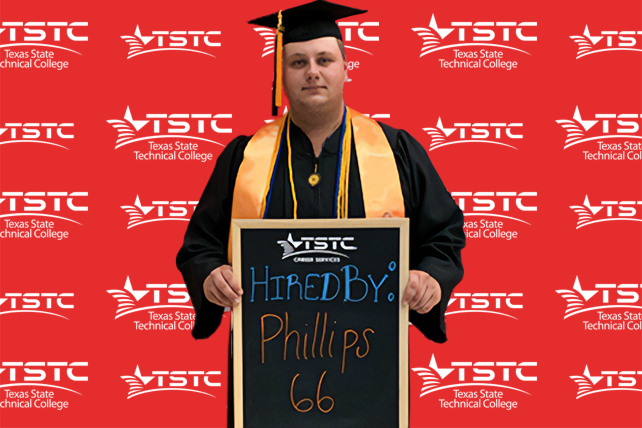 TSTC graduate posing in cap & gown holding a chalkboard showcasing their new employer.