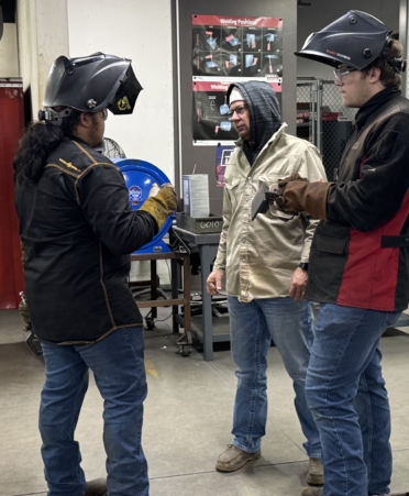 TSTC Welding Technology students Esteban Cruz, left, and Nathan Lemley, right, talk to a Welding Technology instructor about welding techniques ahead of the statewide SkillsUSA competition.