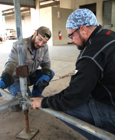 Michael Nagel (right), a TSTC Welding Technology instructor, talks with student Bishop Treto about how pins help hold a scaffolding structure in place.