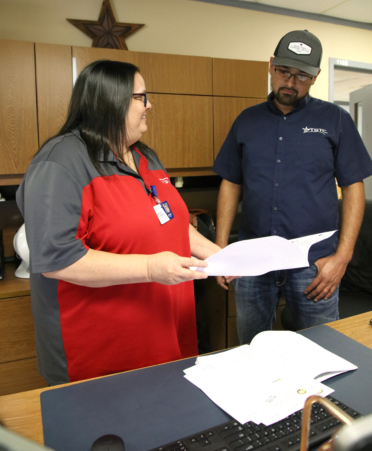 Melissa Guadiana (left), a TSTC Business Management Technology graduate and administrative assistant for TSTC’s Precision Machining Technology and Welding Technology programs, talks with instructor Alvaro Juarez about travel agendas.