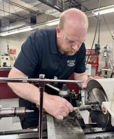 TSTC Precision Machining Technology student Brendan Hills cuts a shaft on a CNC lathe to machine a thumb screw. (Photo courtesy of TSTC.)