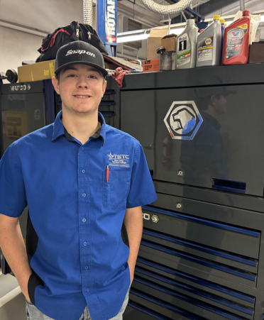 man in blue shirt standing next to toolbox