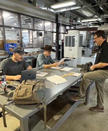 TSTC HVAC Technology students Anthony DiLullo, left, and Andrew DiLullo, center, have their work evaluated by their father, HVAC Technology instructor Chris DiLullo. (Photo courtesy of TSTC.)