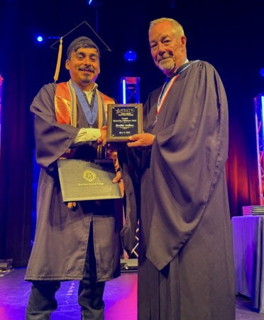 Barzilai Arellano (left), a TSTC Process Operations graduate, receives his Associate of Applied Science degree along with the Provost’s Outstanding Achievement Award from Marshall campus provost Bart Day during the Spring 2025 Commencement. (Photo courtesy of TSTC.)