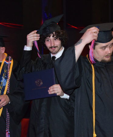 three graduates in caps and gowns