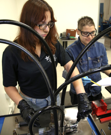 Sophia Galvan (left) and Erica Sanderson, Mechatronics Technology students at TSTC’s Harlingen campus, monitor the pressure and flow of fluid in a hydraulic speed-control circuit during a recent lab session.