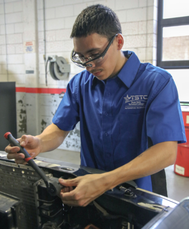 Aaron Munoz, an Automotive Technology student at TSTC’s Harlingen campus, uses a ratchet to remove the radiator from a 2000 Ford Ranger during a recent lab session.