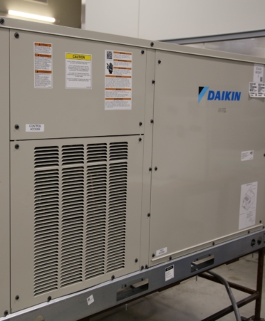 A gray air conditioning unit with the Daikin logo on it.