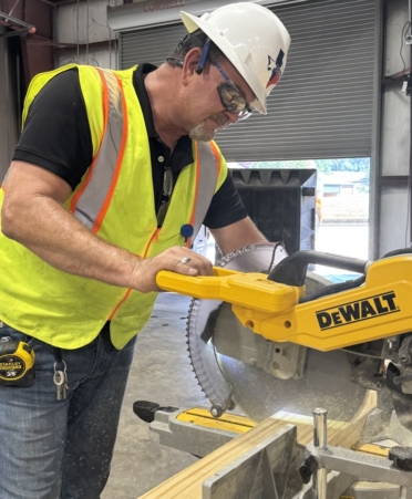 Todd Holloway, a Building Construction instructor at TSTC’s Marshall campus, cuts two-by-six planks to install on material racks for the program’s new lab. (Photo courtesy of TSTC.)