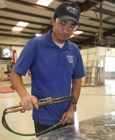 Isaac Melendrez, an Auto Collision and Management Technology student at TSTC’s Harlingen campus, uses a torch on the hood of a 1990 Mercury Cougar during a recent lab session.