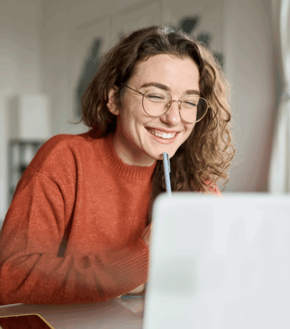 Young girl smiling and working on her laptop