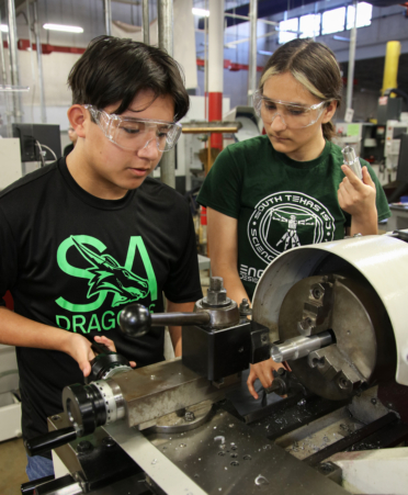 Nathan Pesina (left), a senior at the South Texas Independent School District Science Academy, uses a high-speed lathe to cut steel while his classmate Chelsea Clark observes his work during a recent lab at Texas State Technical College’s Harlingen campus. Pesina and Clark are dual enrollment students in the Precision Machining program.