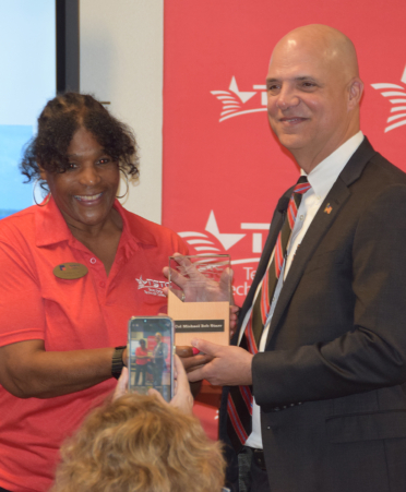Veterans Day-1 lady in red shirt handing plaque to man in suit