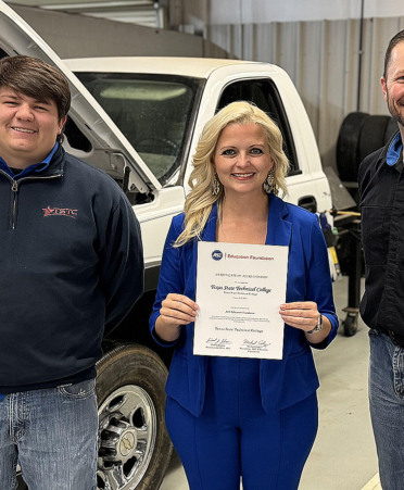 three people in an auto shop