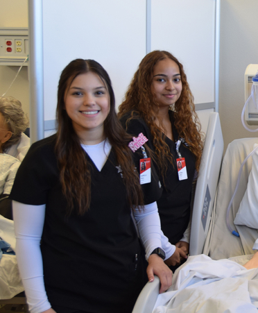 nursing students next to hospital bed