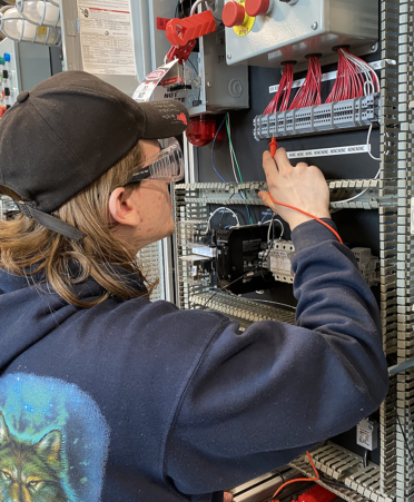 man in blue sweatshirt working on circuit board
