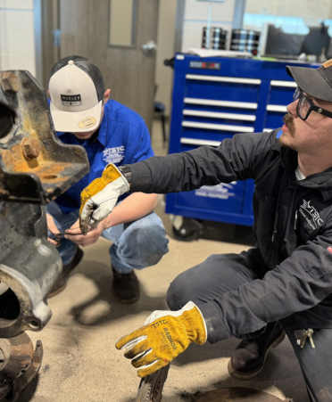 man in grey working on diesel engine